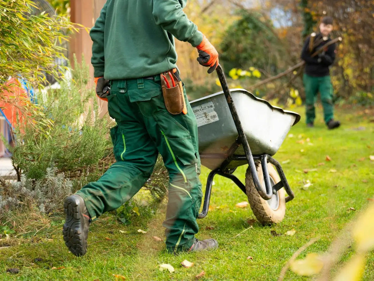 Paysagiste poussant une brouette dans un jardin