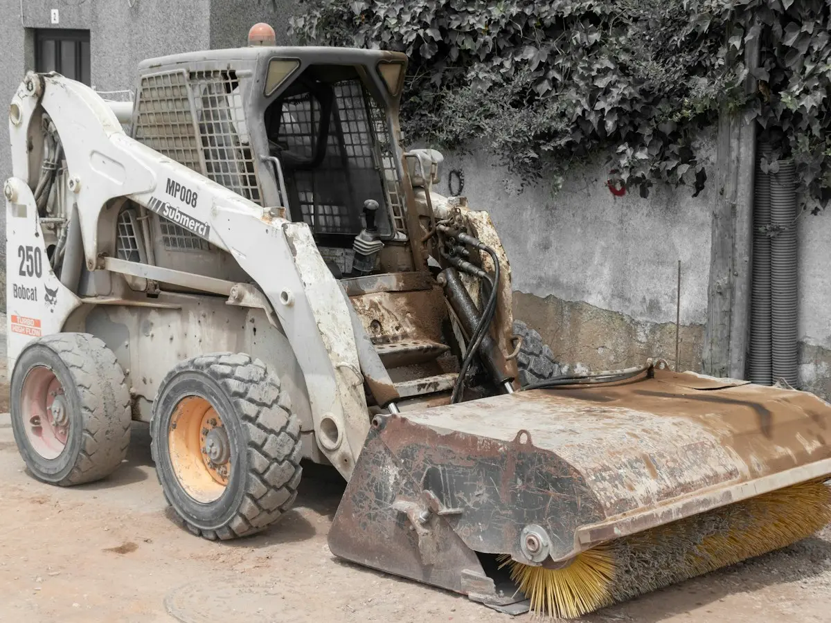 Chargeuse équipée d’une balayeuse sur un chantier